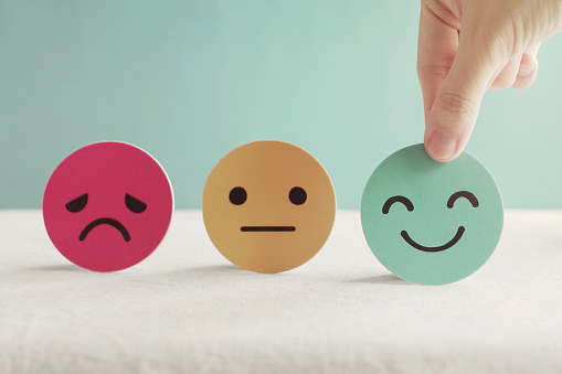 Hand choosing green happy smiley face paper cut